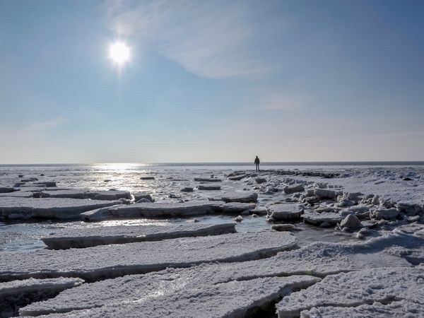 Eisschollen auf der Nordsee mit Spaziergänger im Hintergrund