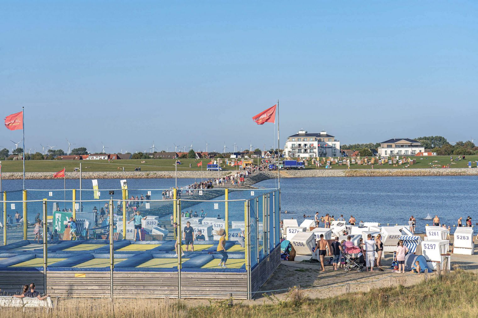 Eine Trampolinanlage und Strandkörbe am Strand von Büsum.