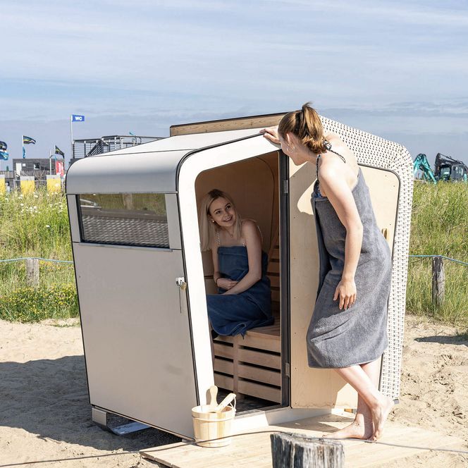 Zwei Frauen nutzen die Strandkorbsauna auf der Familienlagune in Büsum.