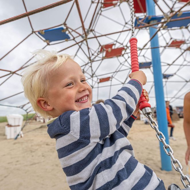 Eine Junge schaukelt auf dem Spielplatz auf der Watt'n Insel.