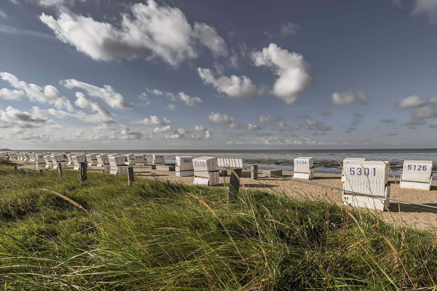 Strandkörbe am Sandstrand auf der Watt'n Insel in der Familienlagune.