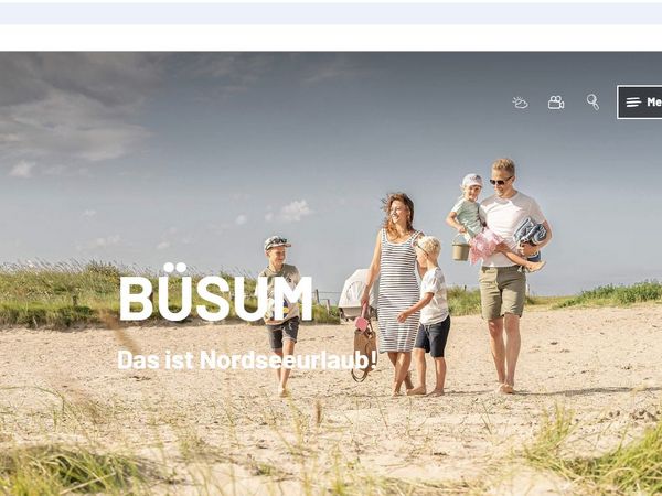 Fünfköpfige Familie läuft im Sommer am Sandstrand der Watt'n Insel, im Hintergrund ein Schlafstrandkorb.