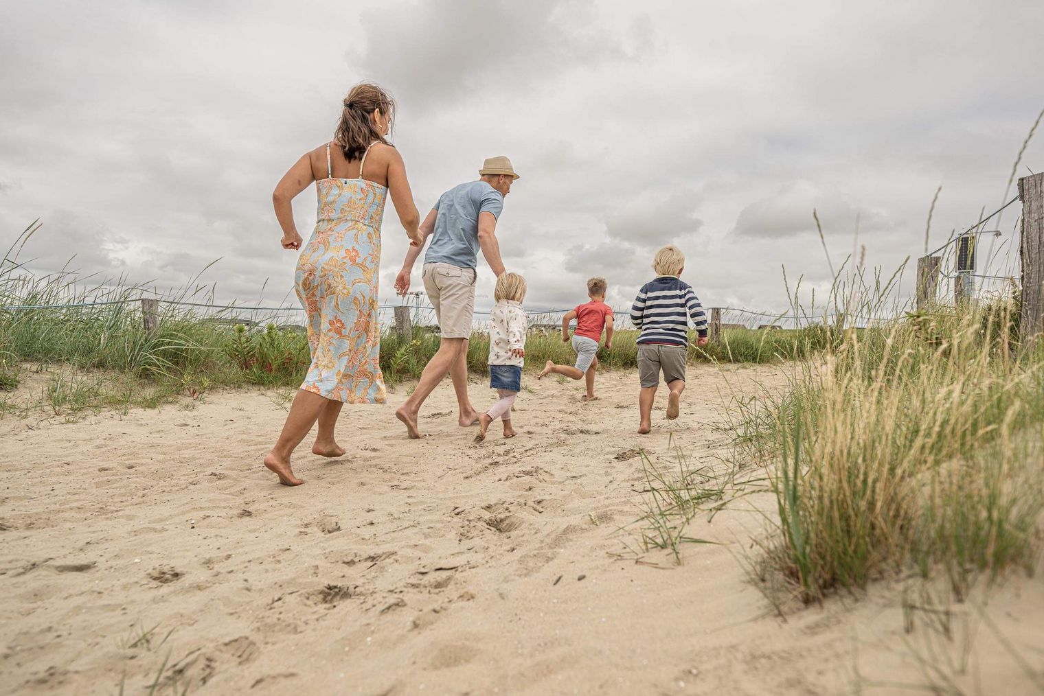 Eine Familie läuft eine Düne hoch am Büsumer Sandstrand.