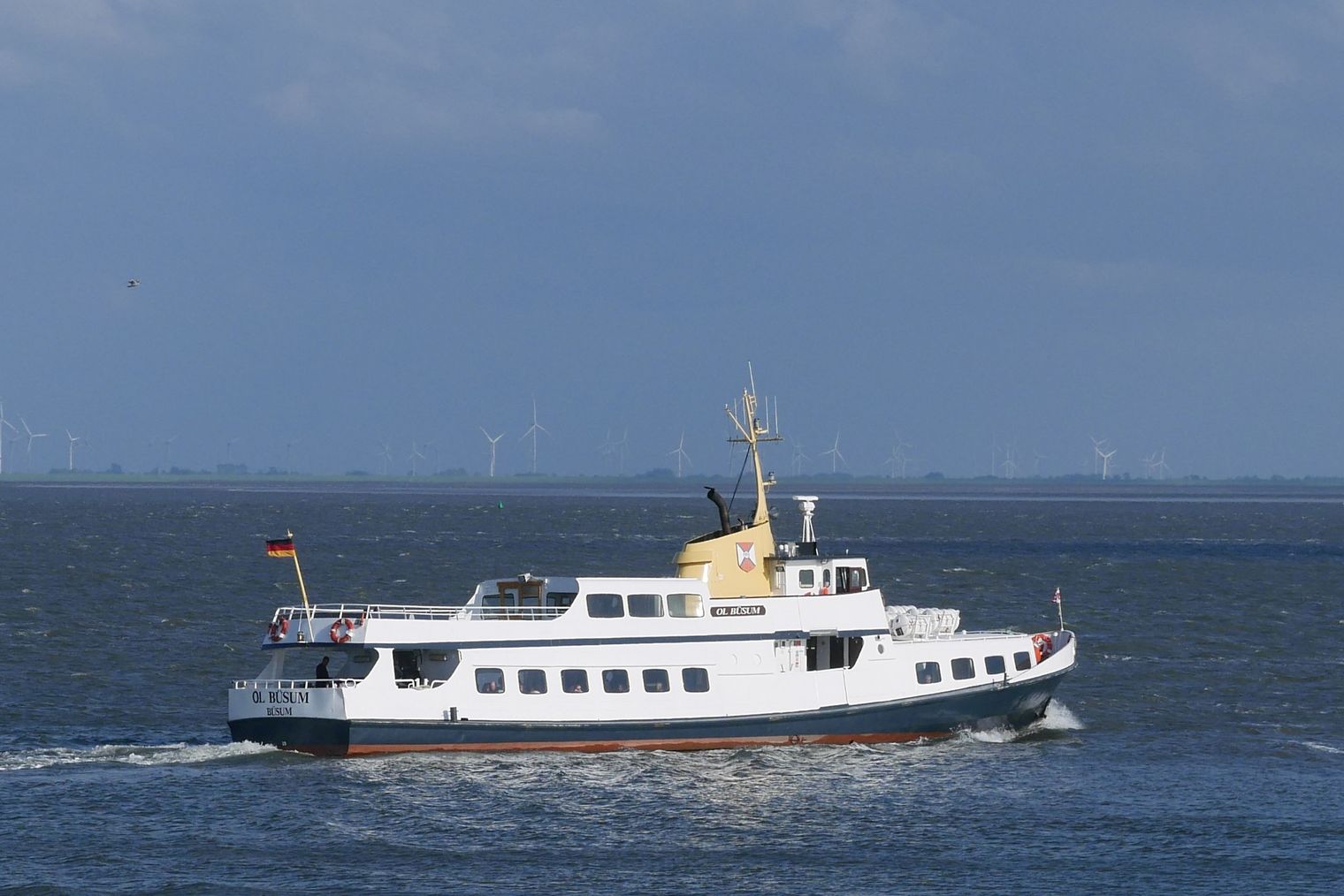 Ein weißes Schiff auf dem Meer bei blauem Himmel.