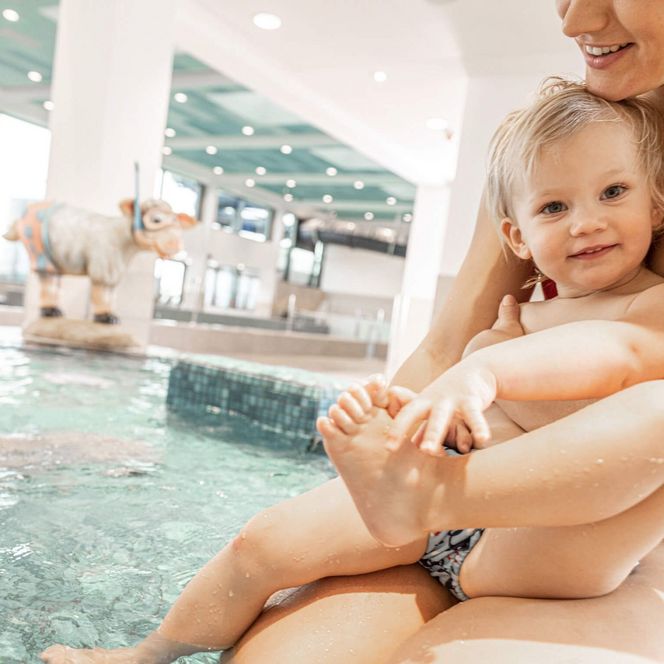 Ein kleines Mädchen auf dem Arm seiner Mutter beim Babybecken in der Meerzeit Büsum.