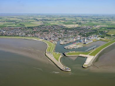 Luftaufnahme von Grünstrand und Hafeneinfahrt mit Sperrwerk in Büsum.