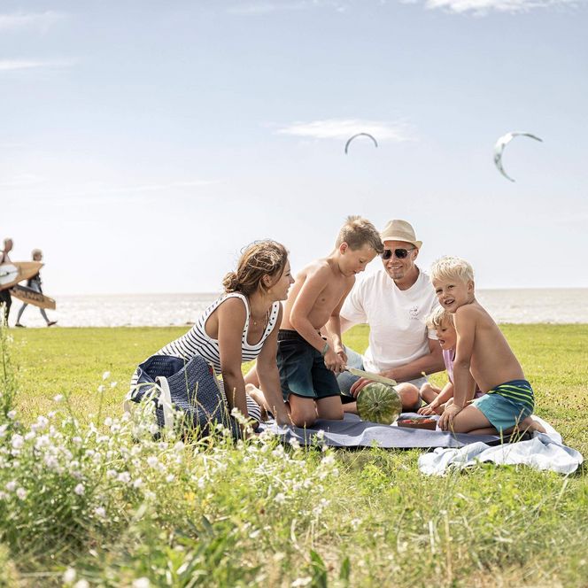 Eine Familie beim Picknick auf der Watt'n Insel in der Familienlagune.