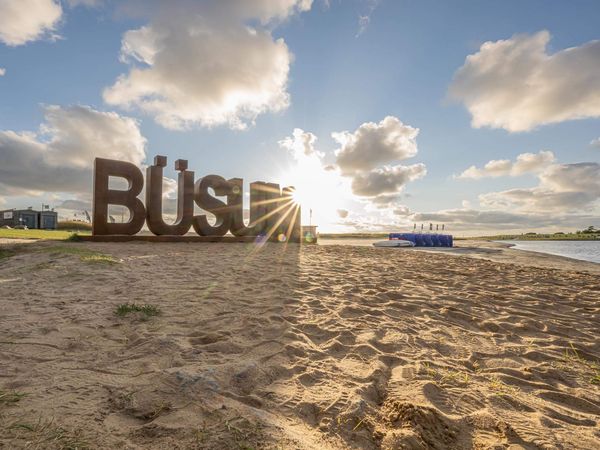 Der große Büsum-Schriftzug bei Sonnenuntergang auf der Watt'n Insel in der Familienlagune.