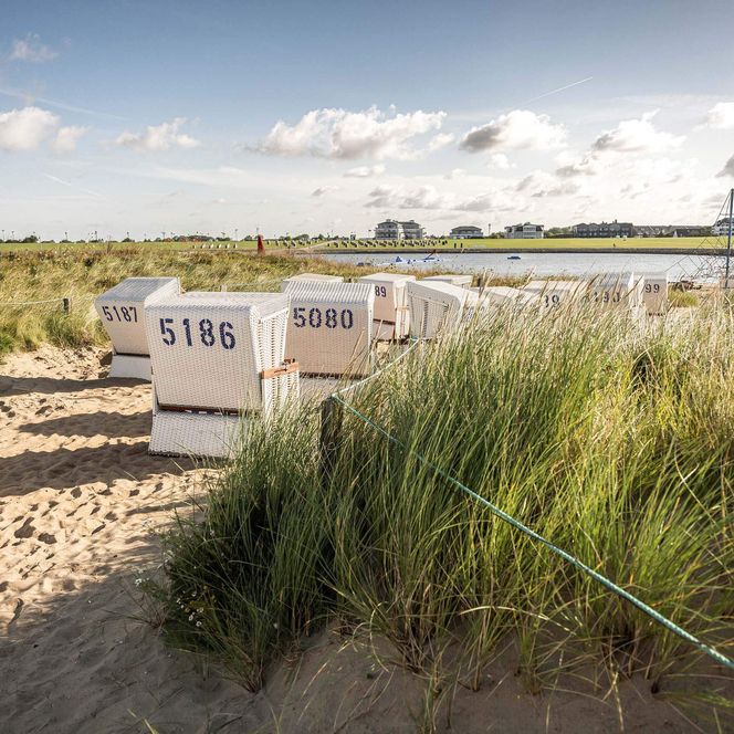 Strandkörbe am Sandstrand auf der Watt'n Insel in der Familienlagune.