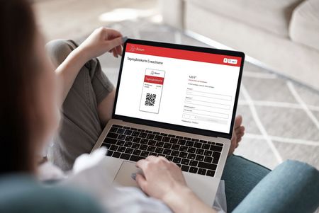 Eine Person mit einem Laptop, auf dem die Wepapp aufgerufen ist.