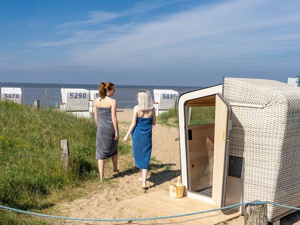 Zwei Freundinnen saunieren in der Strandkorbsauna in Büsum am Meer.