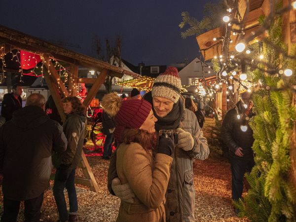 Paar vor Buden beim Büsumer Winterzauber Weihnachtsmarkt.