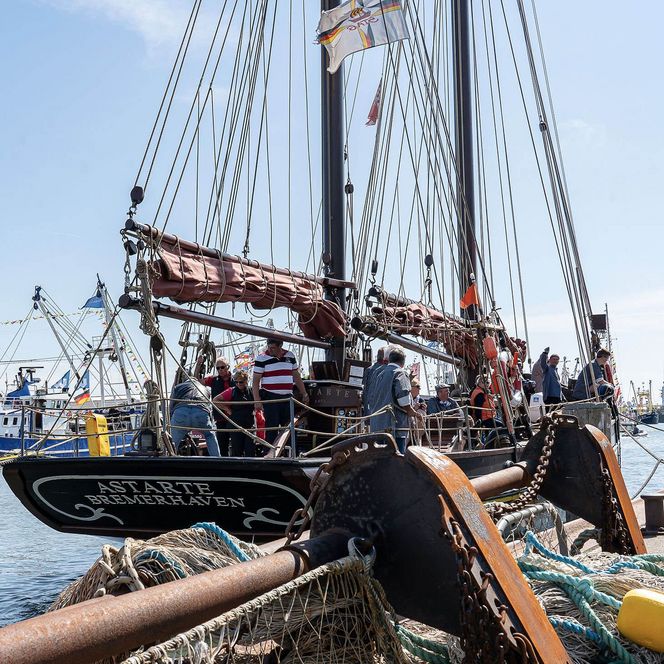 Personen sind an den Kutterregattatagen auf einem Segelboot im Büsumer Hafen.