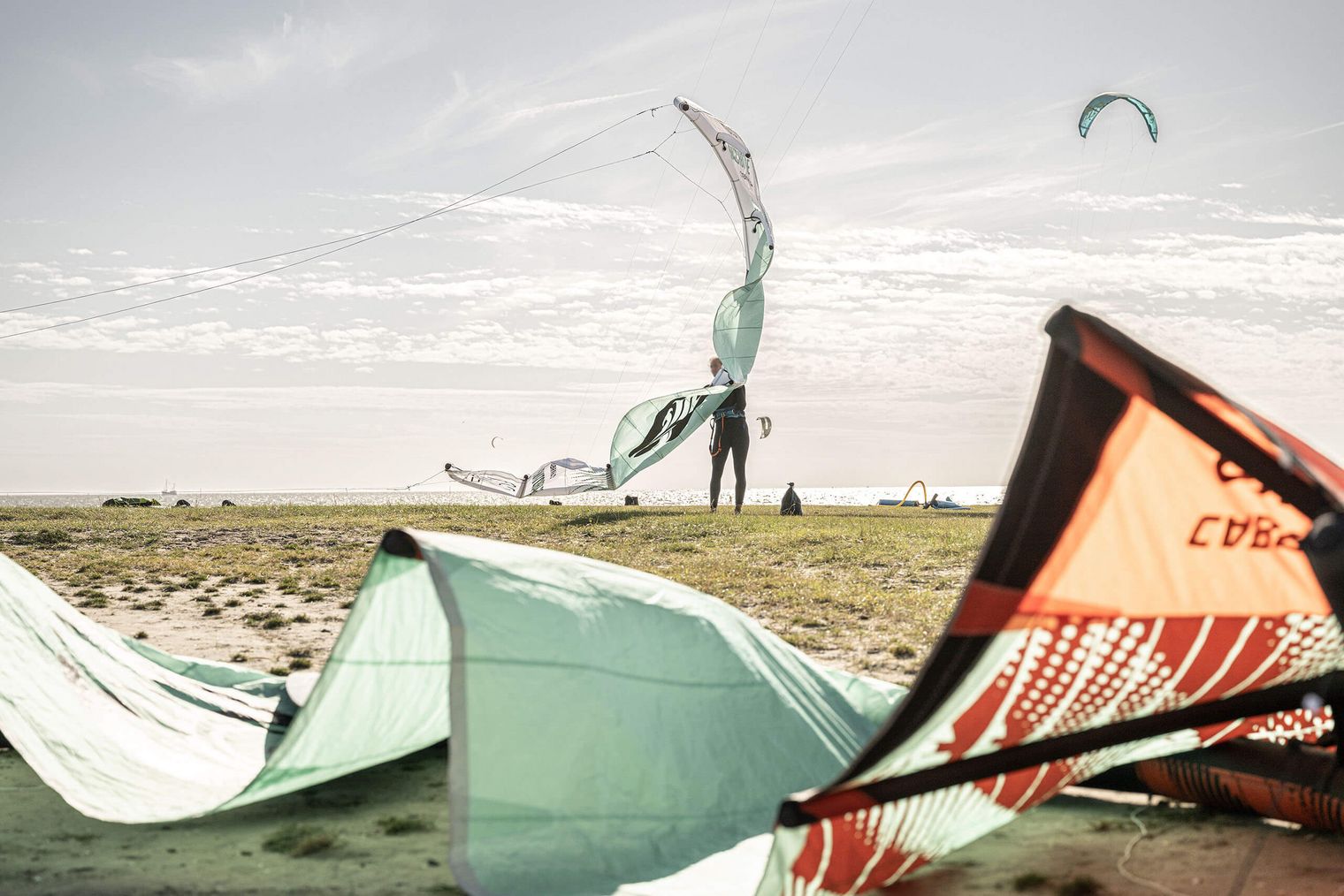 Eine Kite-Surferin mit Equipment auf der Watt'n Insel in der Familienlagune.