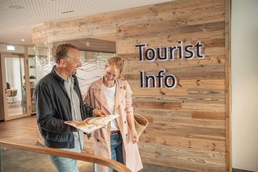 Ein Paar liest ein Magazin an der Tourist-Information im Büsumer Watt'n Hus.