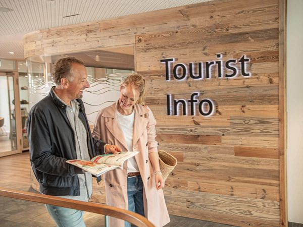 Ein Paar liest ein Magazin an der Tourist-Information im Büsumer Watt'n Hus.