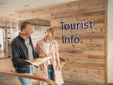 Ein Paar liest ein Magazin an der Tourist-Information im Büsumer Watt'n Hus.