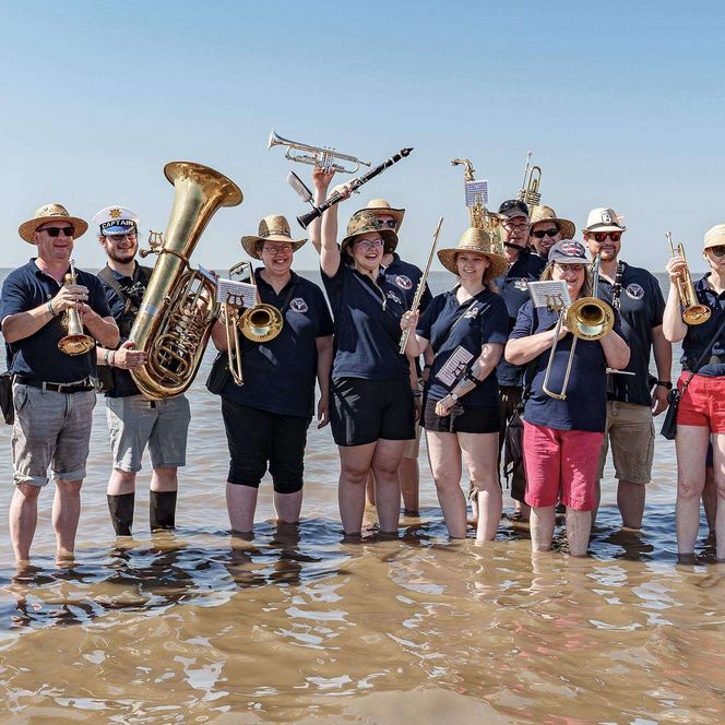 Der Musikzug Wacken Firefighters beim Büsumer Wattenlaufen mit Musik.