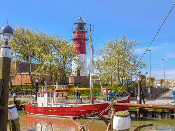 Büsumer Leuchtturm mit Schiffen im Museumshafen