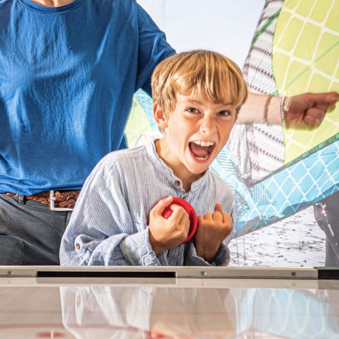 Ein Junge feiert seinen Sieg beim Airhockey in der Deichbude im Büsumer Watt'n Hus.