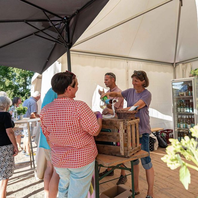 Gäste probieren den Wein eines Weinbaubetriebes aus Weinstadt auf dem Winzerfest am Büsumer Ankerplatz.